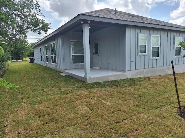 504 S Story Sts, Florence, TX 76527 - view of side of home featuring board and batten siding, a patio area, and a yard