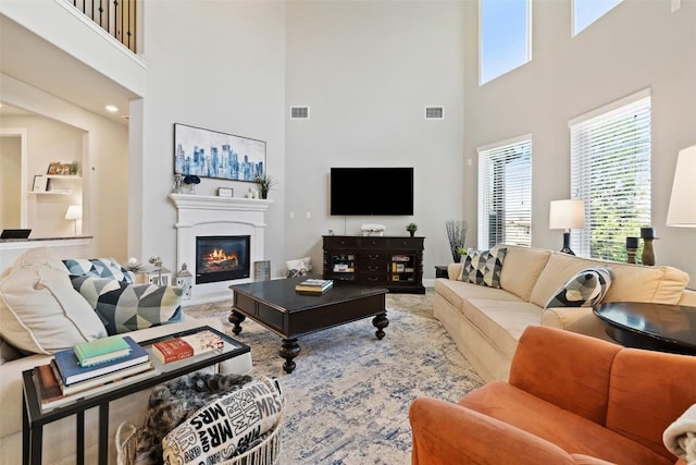 4225 Borho Ranch St, Leander, TX 78641 - living room featuring a towering ceiling, a glass covered fireplace, and carpet floors