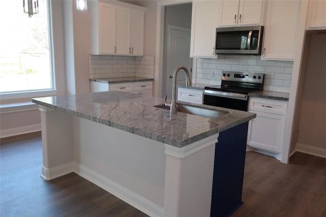 119 Waimanalo Dr, Bastrop, TX 78602 - kitchen featuring stainless steel appliances, dark wood finished floors, light stone counters, and white cabinetry