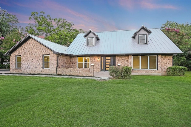 503 Elm St, Bastrop, TX 78602 - view of front of property featuring a front yard, brick siding, and a metal roof