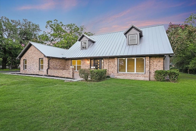 503 Elm St, Bastrop, TX 78602 - view of front of house featuring a lawn, brick siding, and a metal roof