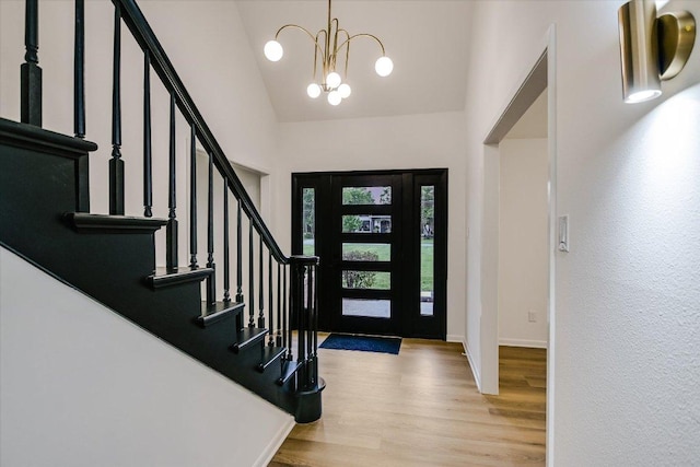 503 Elm St, Bastrop, TX 78602 - foyer entrance featuring high vaulted ceiling, wood finished floors, a chandelier, and stairs