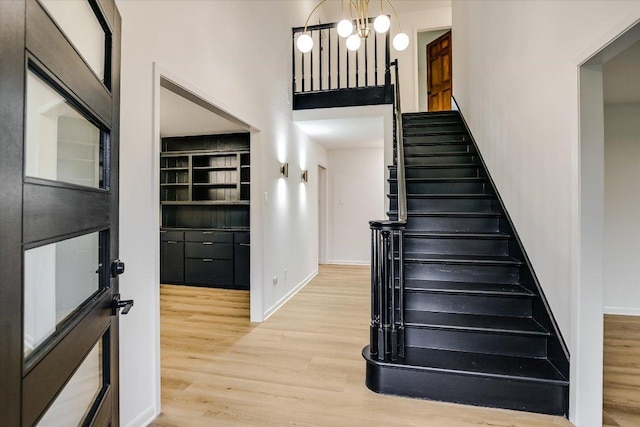 503 Elm St, Bastrop, TX 78602 - staircase with wood finished floors, a towering ceiling, and a chandelier
