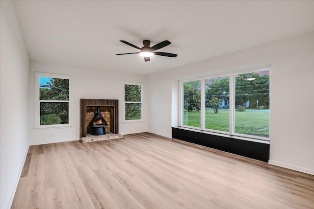 503 Elm St, Bastrop, TX 78602 - unfurnished living room featuring a wood stove, wood finished floors, and ceiling fan