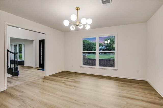 503 Elm St, Bastrop, TX 78602 - spare room featuring a chandelier, light wood-style flooring, and stairway