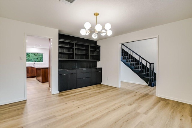 503 Elm St, Bastrop, TX 78602 - unfurnished room featuring a chandelier, stairs, and light wood finished floors
