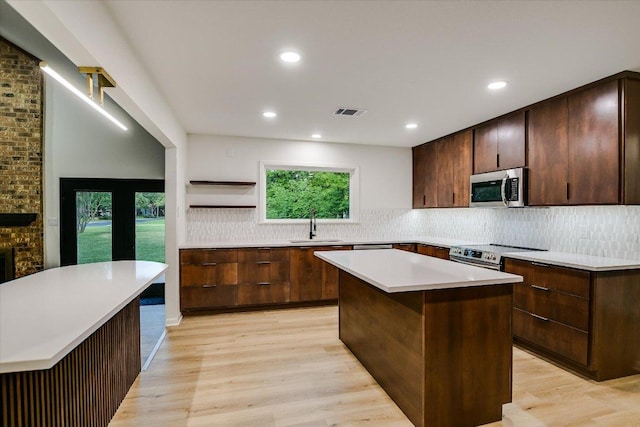 503 Elm St, Bastrop, TX 78602 - kitchen with stainless steel appliances, a kitchen island, backsplash, light wood-type flooring, and recessed lighting