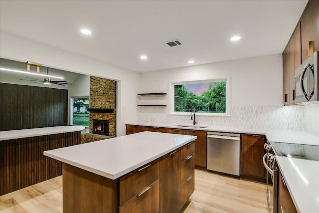 503 Elm St, Bastrop, TX 78602 - kitchen with stainless steel appliances, modern cabinets, light wood finished floors, a center island, and recessed lighting
