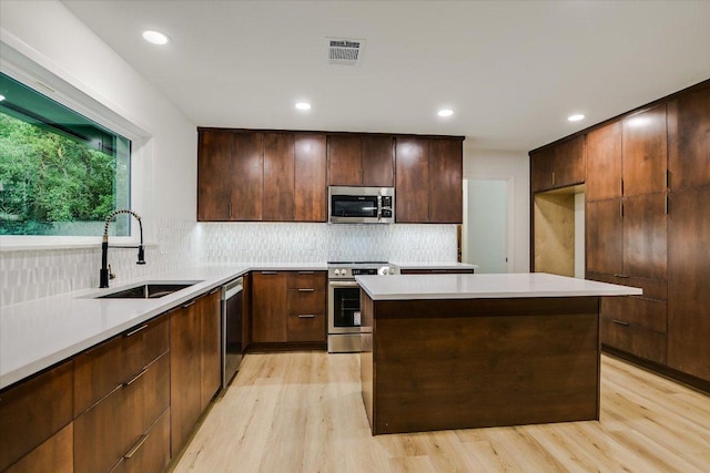 503 Elm St, Bastrop, TX 78602 - kitchen with stainless steel appliances, light wood finished floors, backsplash, light countertops, and recessed lighting