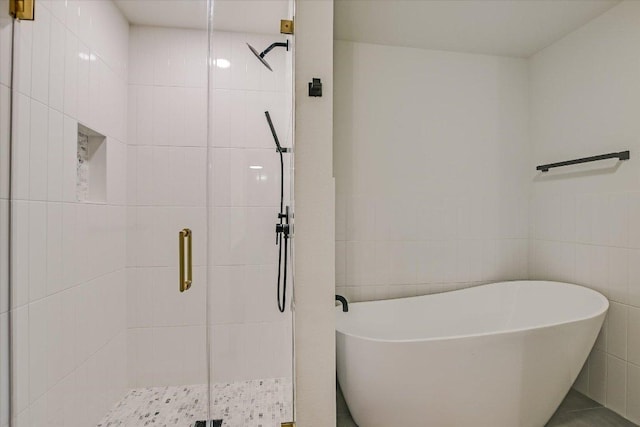 503 Elm St, Bastrop, TX 78602 - bathroom with tile walls, a freestanding bath, and a stall shower