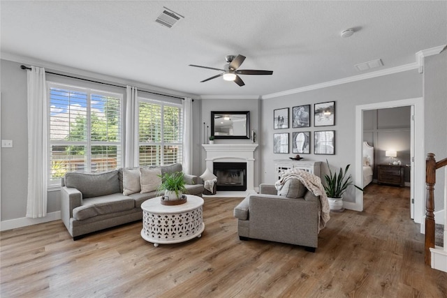 3431 Ranch Park Trl, Round Rock, TX 78681 - living area featuring a ceiling fan, crown molding, a glass covered fireplace, and wood finished floors