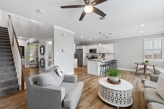 3431 Ranch Park Trl, Round Rock, TX 78681 - living area with crown molding, arched walkways, stairway, ceiling fan, and recessed lighting