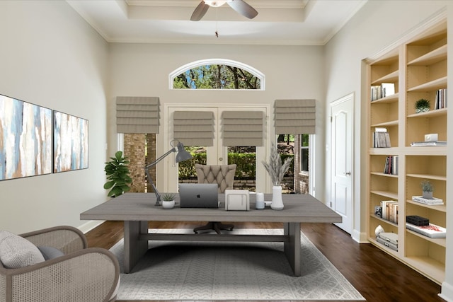 138 Top O The Lake Dr, Lakeway, TX 78734 - office area featuring dark wood-type flooring, a ceiling fan, built in shelves, ornamental molding, and a raised ceiling