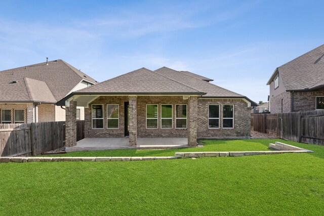 1816 Arapaho Mountain Pass, Leander, TX 78641 - back of property with brick siding, a patio area, a fenced backyard, and a shingled roof