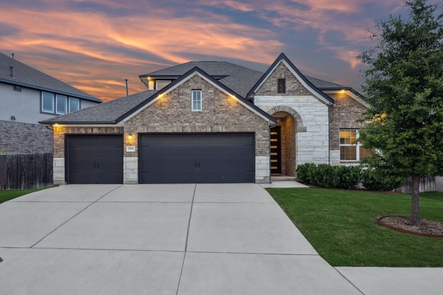 1816 Arapaho Mountain Pass, Leander, TX 78641 - french country inspired facade featuring a garage, concrete driveway, stone siding, and a shingled roof