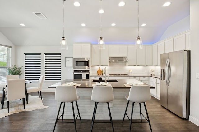 1816 Arapaho Mountain Pass, Leander, TX 78641 - kitchen with appliances with stainless steel finishes, lofted ceiling, dark countertops, backsplash, and a kitchen bar