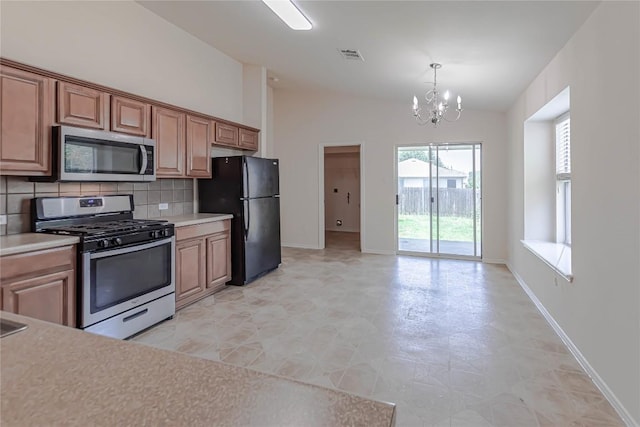 1504 Morning Mist Ln, Pflugerville, TX 78660 - kitchen featuring stainless steel appliances, a chandelier, healthy amount of natural light, decorative backsplash, and lofted ceiling