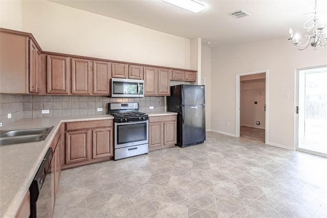 1504 Morning Mist Ln, Pflugerville, TX 78660 - kitchen with black appliances, backsplash, a chandelier, and light countertops