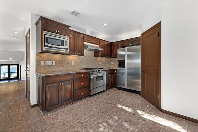 10810 River Terrace Cir, Austin, TX 78733 - kitchen with appliances with stainless steel finishes, under cabinet range hood, tasteful backsplash, dark brown cabinets, and recessed lighting