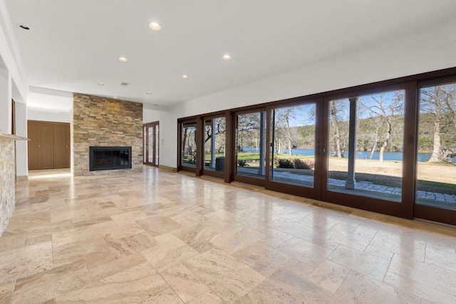 10810 River Terrace Cir, Austin, TX 78733 - unfurnished living room with recessed lighting, a stone fireplace, and stone tile flooring