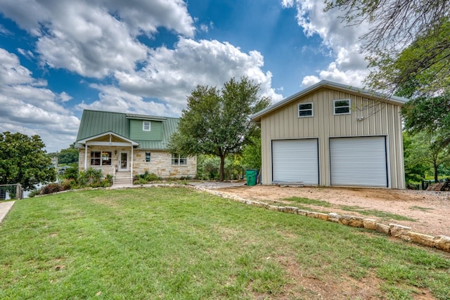 134 Glen Oaks Dr, Sunrise Beach, TX 78643 - view of front facade with an outbuilding, a front lawn, stone siding, a metal roof, and a detached garage