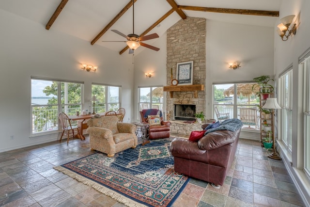 134 Glen Oaks Dr, Sunrise Beach, TX 78643 - living area featuring stone tile flooring, high vaulted ceiling, a ceiling fan, beamed ceiling, and a fireplace