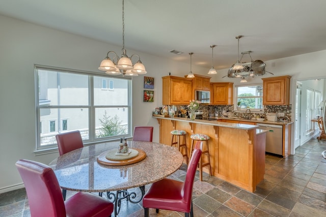 134 Glen Oaks Dr, Sunrise Beach, TX 78643 - dining space with a chandelier and stone tile flooring