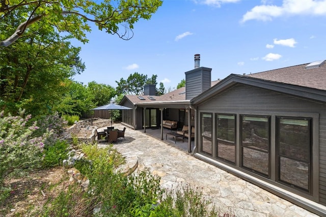 103 Schooner Dr, Lakeway, TX 78738 - back of property featuring a patio area, a chimney, an outdoor living space, and a shingled roof