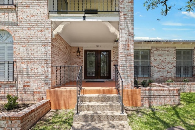 7606 Mesa Dr, Austin, TX 78731 - view of exterior entry with french doors, brick siding, and a balcony
