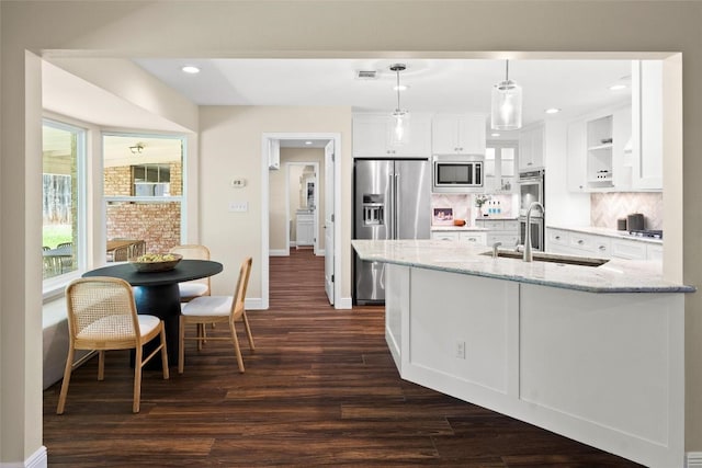 7606 Mesa Dr, Austin, TX 78731 - kitchen with stainless steel appliances, dark wood-style floors, white cabinets, light stone counters, and recessed lighting
