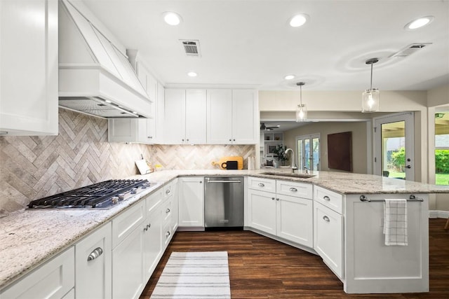 7606 Mesa Dr, Austin, TX 78731 - kitchen with stainless steel appliances, custom range hood, a peninsula, white cabinetry, and dark wood finished floors