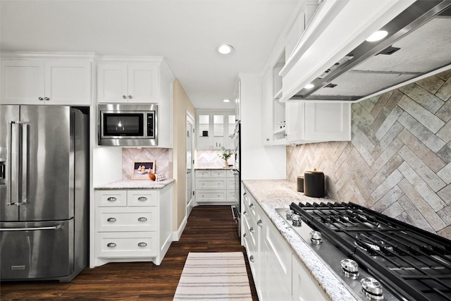 7606 Mesa Dr, Austin, TX 78731 - kitchen with appliances with stainless steel finishes, custom range hood, white cabinetry, light stone counters, and recessed lighting
