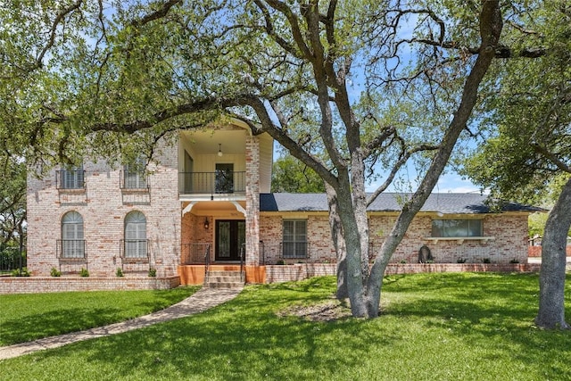 7606 Mesa Dr, Austin, TX 78731 - view of front of property featuring a balcony, brick siding, and a front lawn