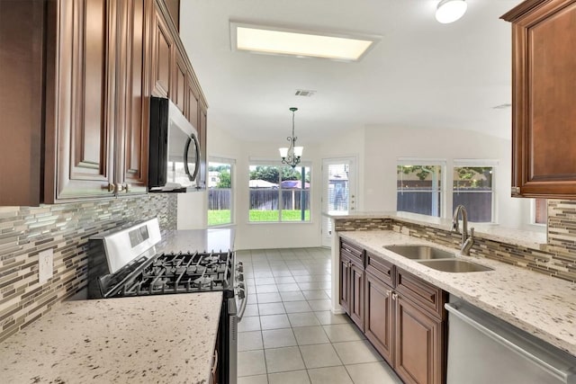 1718 Zydeco Dr, Round Rock, TX 78664 - kitchen featuring stainless steel appliances, backsplash, light tile patterned floors, light stone counters, and decorative light fixtures