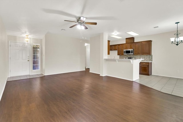 1718 Zydeco Dr, Round Rock, TX 78664 - unfurnished living room featuring ceiling fan, a chandelier, and wood finished floors