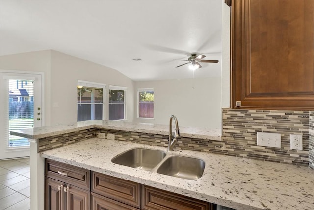 1718 Zydeco Dr, Round Rock, TX 78664 - kitchen featuring backsplash, a ceiling fan, vaulted ceiling, light stone counters, and tile patterned flooring