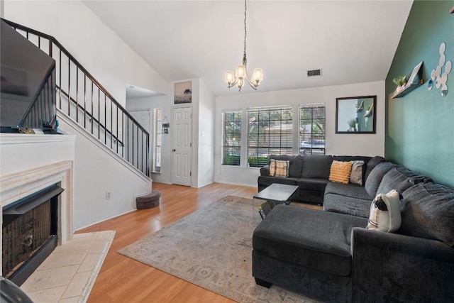 1424 Roxannes Run, Pflugerville, TX 78660 - living area featuring a chandelier, stairway, wood finished floors, a fireplace, and high vaulted ceiling