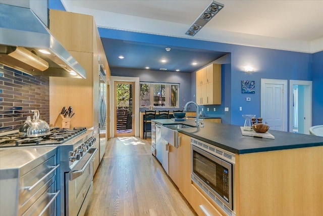 2109 Nickerson St, Austin, TX 78704 - kitchen featuring range hood, stainless steel appliances, light brown cabinets, light wood-style flooring, and modern cabinets