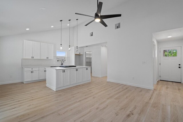3405 Dunliegh Dr, Austin, TX 78745 - kitchen with high vaulted ceiling, open floor plan, white cabinetry, ceiling fan, and light wood finished floors