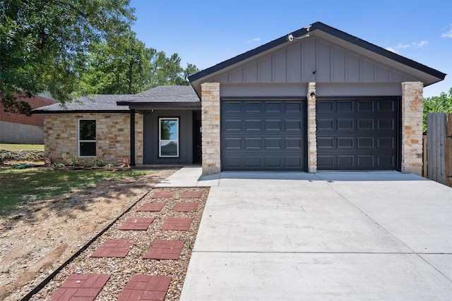 3405 Dunliegh Dr, Austin, TX 78745 - view of front facade with board and batten siding, concrete driveway, a garage, and stone siding