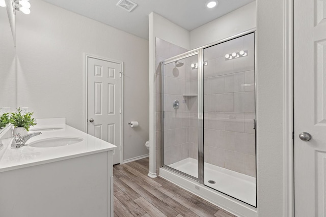 1925 T H Johnson Dr, Taylor, TX 76574 - bathroom featuring double vanity, a stall shower, and wood finished floors