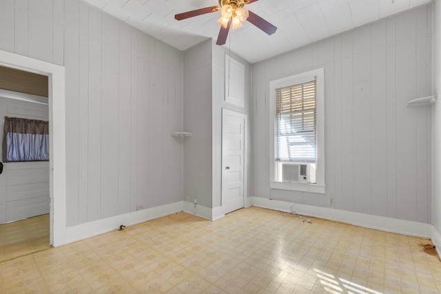 1006 Porter St, Taylor, TX 76574 - empty room with a ceiling fan, tile patterned floors, cooling unit, and wood walls