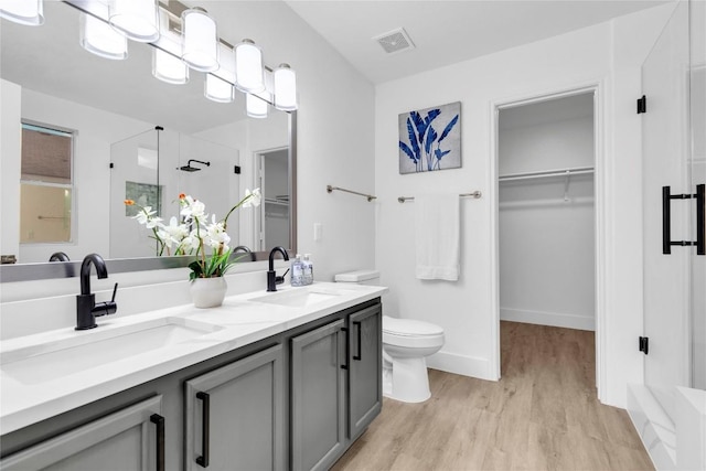111 Woodley Rd, Leander, TX 78641 - full bath with a shower stall, wood finished floors, a walk in closet, and double vanity