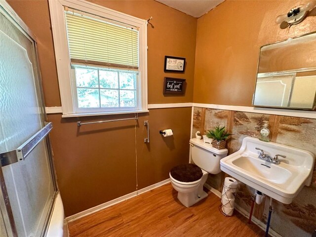 407 4th Ave, Smithville, TX 78957 - bathroom with wood finished floors, a shower with shower door, and a wainscoted wall