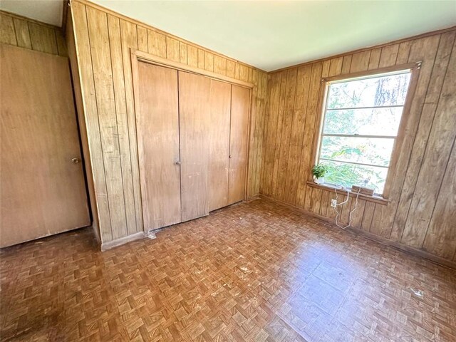 407 4th Ave, Smithville, TX 78957 - unfurnished bedroom featuring wood walls and a closet