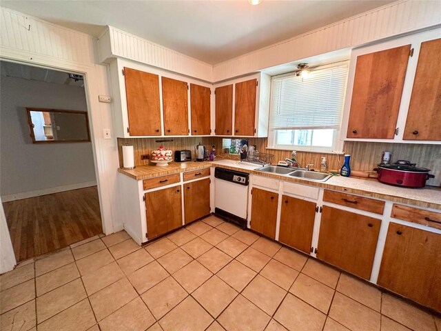 407 4th Ave, Smithville, TX 78957 - kitchen with white dishwasher, light countertops, brown cabinets, and light tile patterned floors