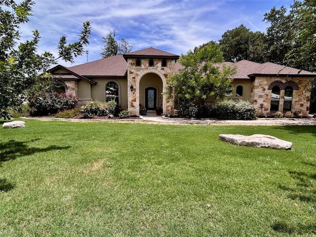 304 Bluestem Cv, Georgetown, TX 78633 - mediterranean / spanish-style house with stone siding, a front yard, and stucco siding