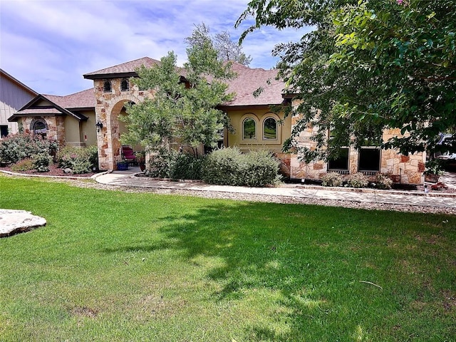 304 Bluestem Cv, Georgetown, TX 78633 - view of front facade with stone siding, a front lawn, stucco siding, and roof with shingles