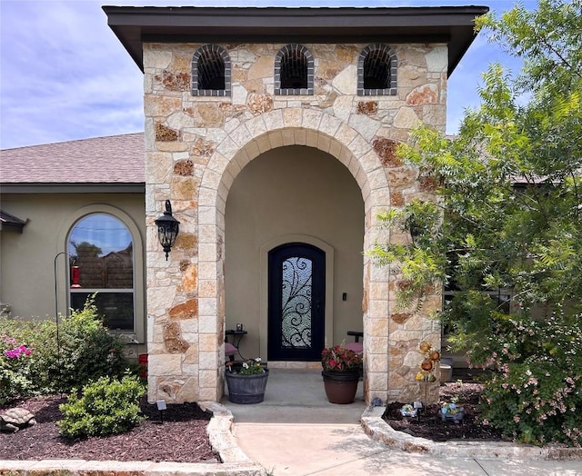 304 Bluestem Cv, Georgetown, TX 78633 - doorway to property featuring stone siding, a shingled roof, and stucco siding