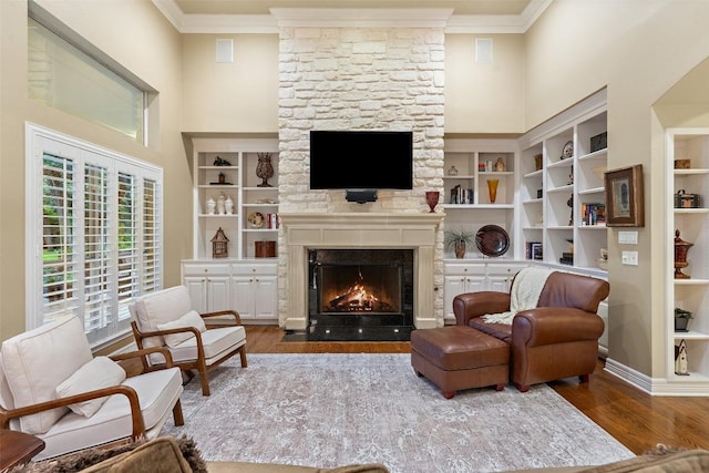 2319 Woodway Dr, Round Rock, TX 78681 - living area with ornamental molding, a fireplace, wood finished floors, a high ceiling, and built in features